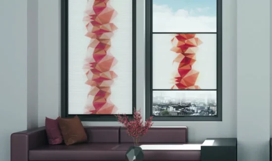 Zwei Fenster mit Wabenplissees von MHZ mit einem Design geometrischer Formen in Rottönen. Das eine Fenster wird voll verdeckt, das andere zur Hälfte.