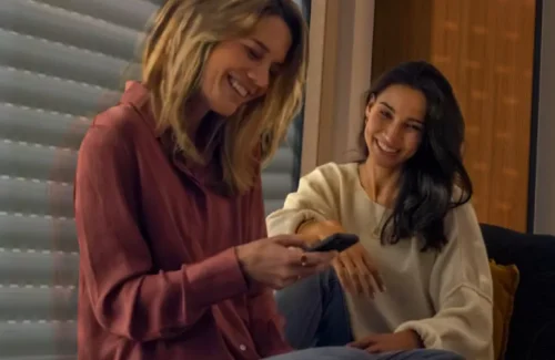 Zwei Frauen steuern ihr Smart Home komfortabel über die Somfy Smartphone App an.