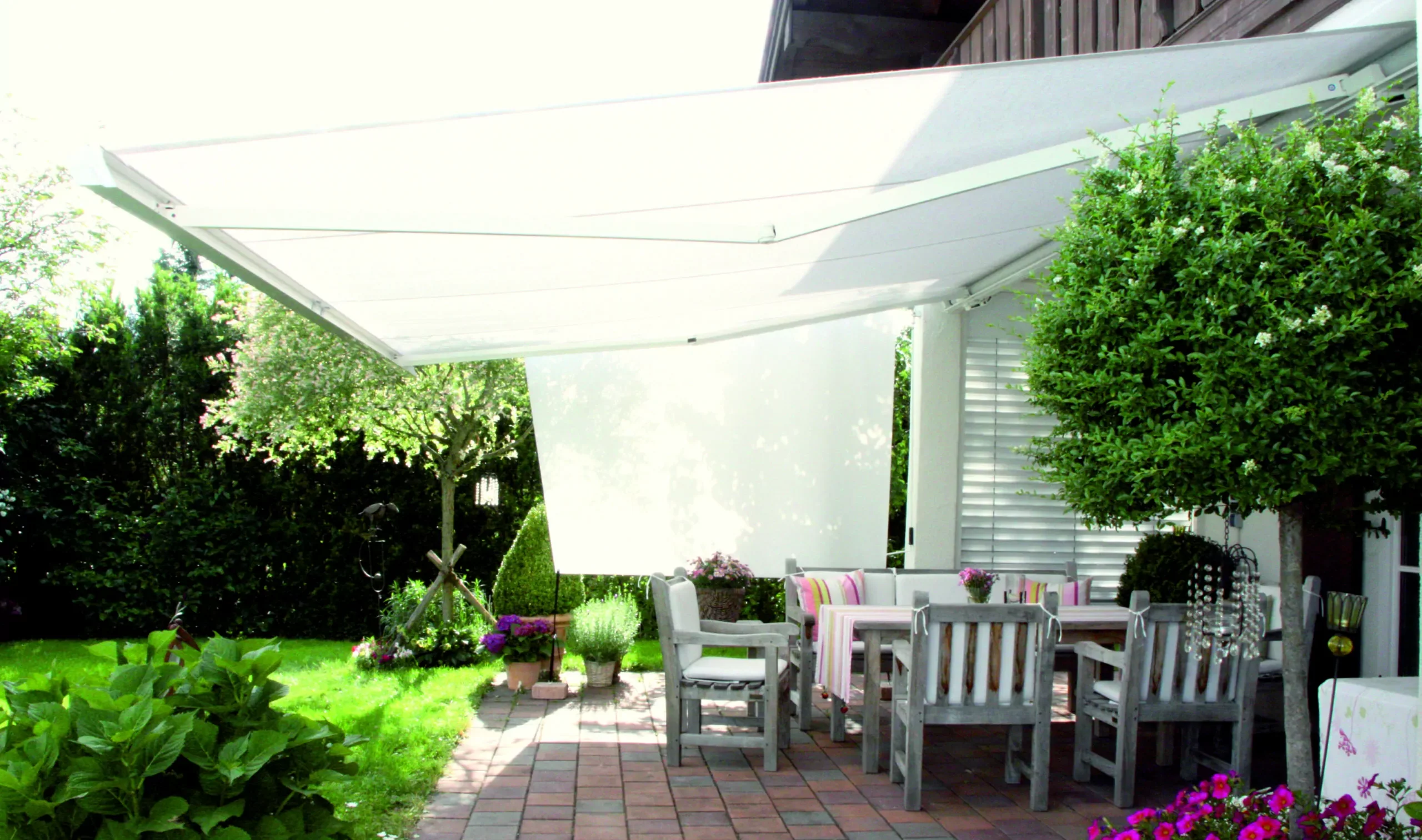 Sonnensegel Shadesign SKUGGI® in Kombination mit einer dazu passenden Markise als Sonnenschutz für einer Terrasse.